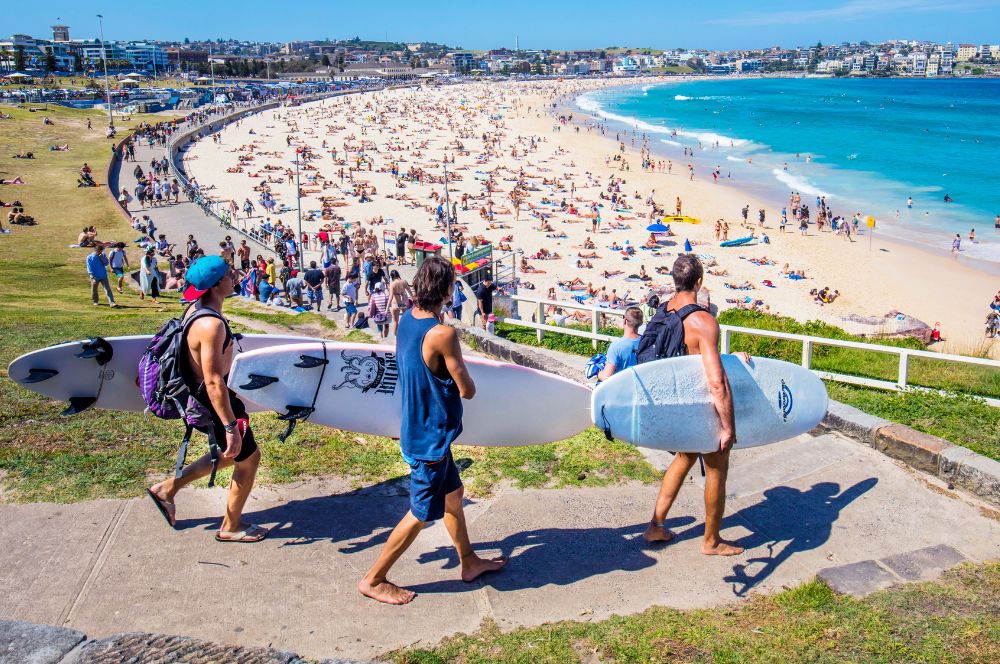 Surfers and sunbathers on golden sand at Bondi Beach